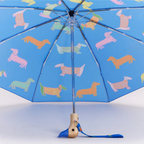 Αναδιπλούμενη ομπρέλα Original Duckhead Dogs In Blue σε μπλε φόντο με εικονογραφημένους σκύλους και χειροποίητη ξύλινη λαβή πάπιας.