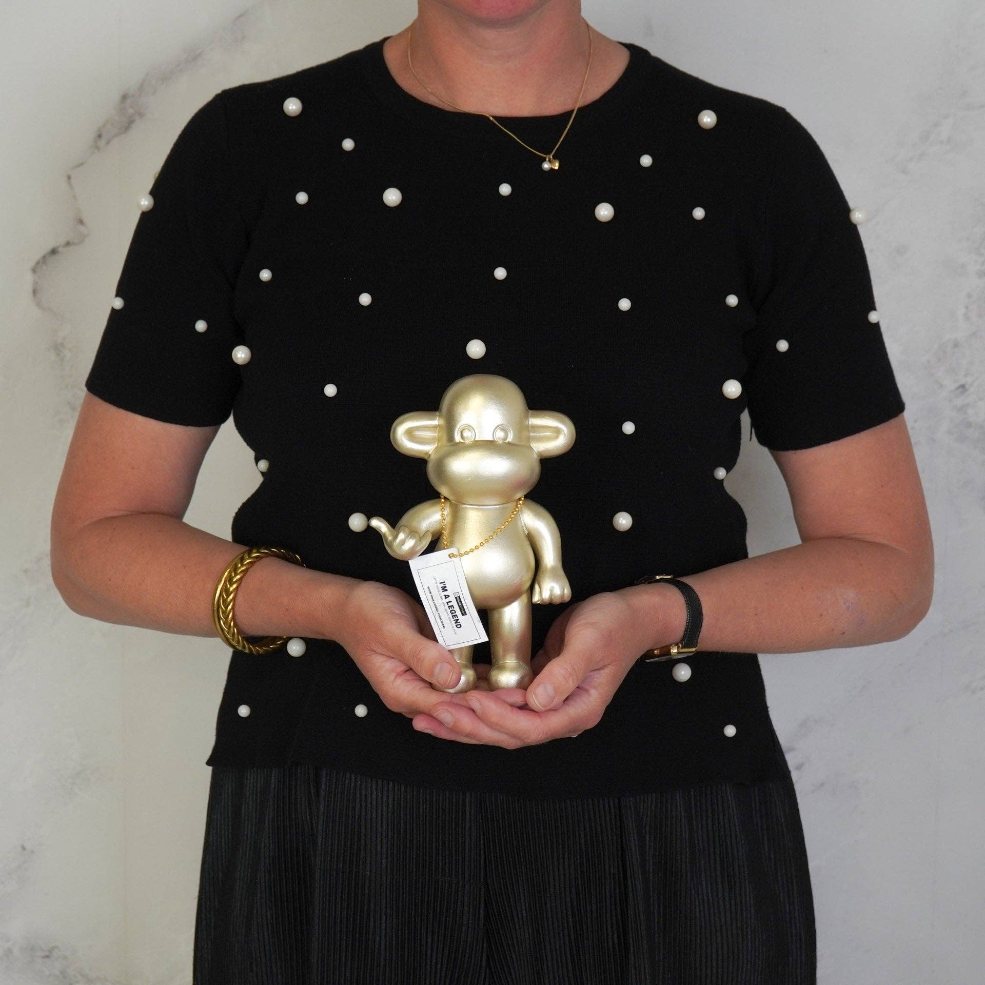 Διακοσμητική χρυσή μαϊμού House Vitamin σε μέγεθος Medium, που κάνει τη χειρονομία "Hang Loose".