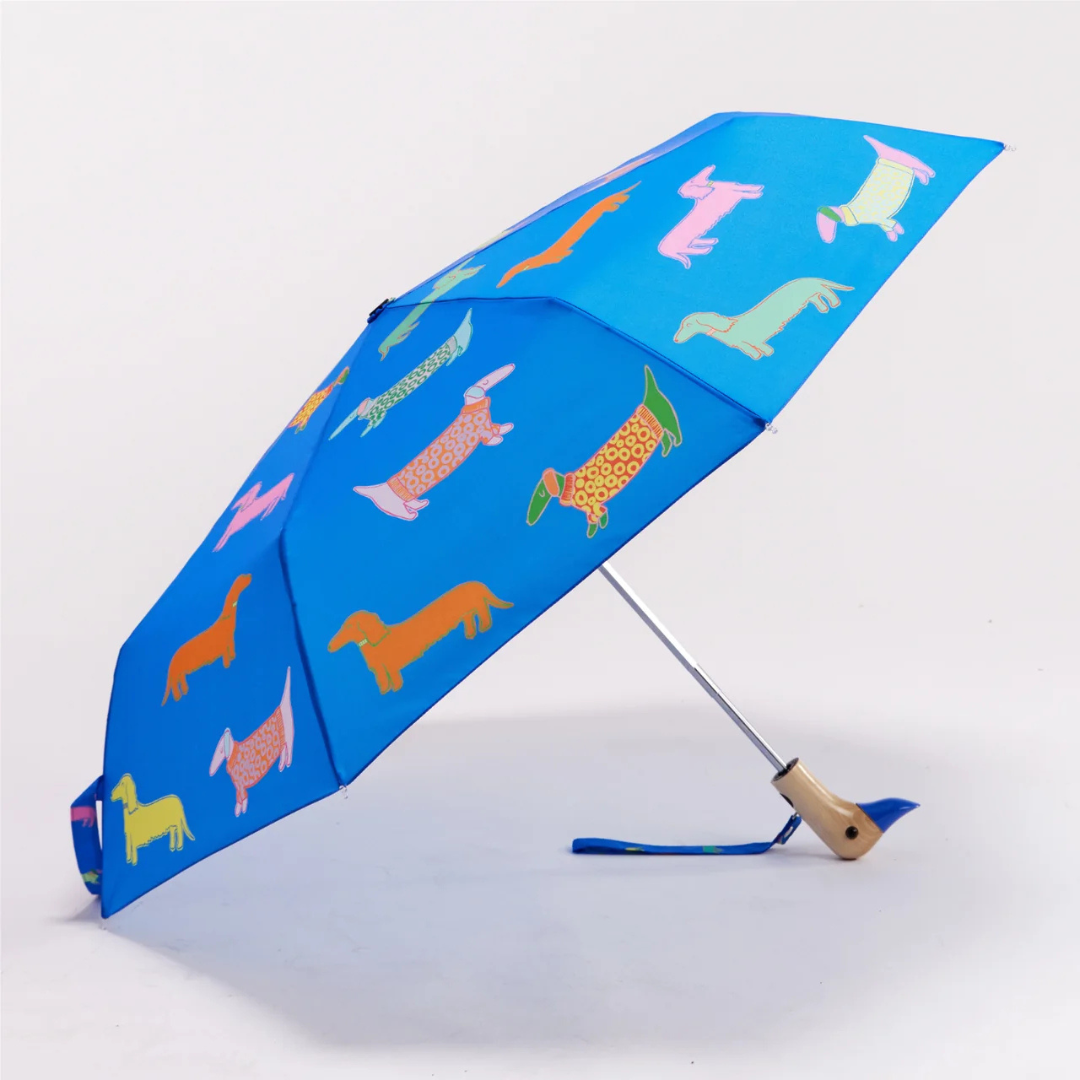 Αναδιπλούμενη ομπρέλα Original Duckhead Dogs In Blue σε μπλε φόντο με εικονογραφημένους σκύλους και χειροποίητη ξύλινη λαβή πάπιας.