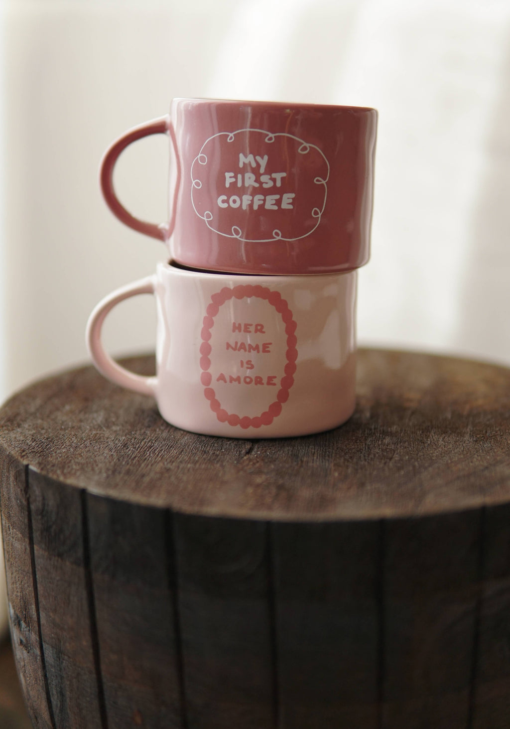 Χειροποίητη κεραμική κούπα σε off-white χρώμα με τη μαύρη επιγραφή "my first coffee" και γυαλιστερό φινίρισμα.