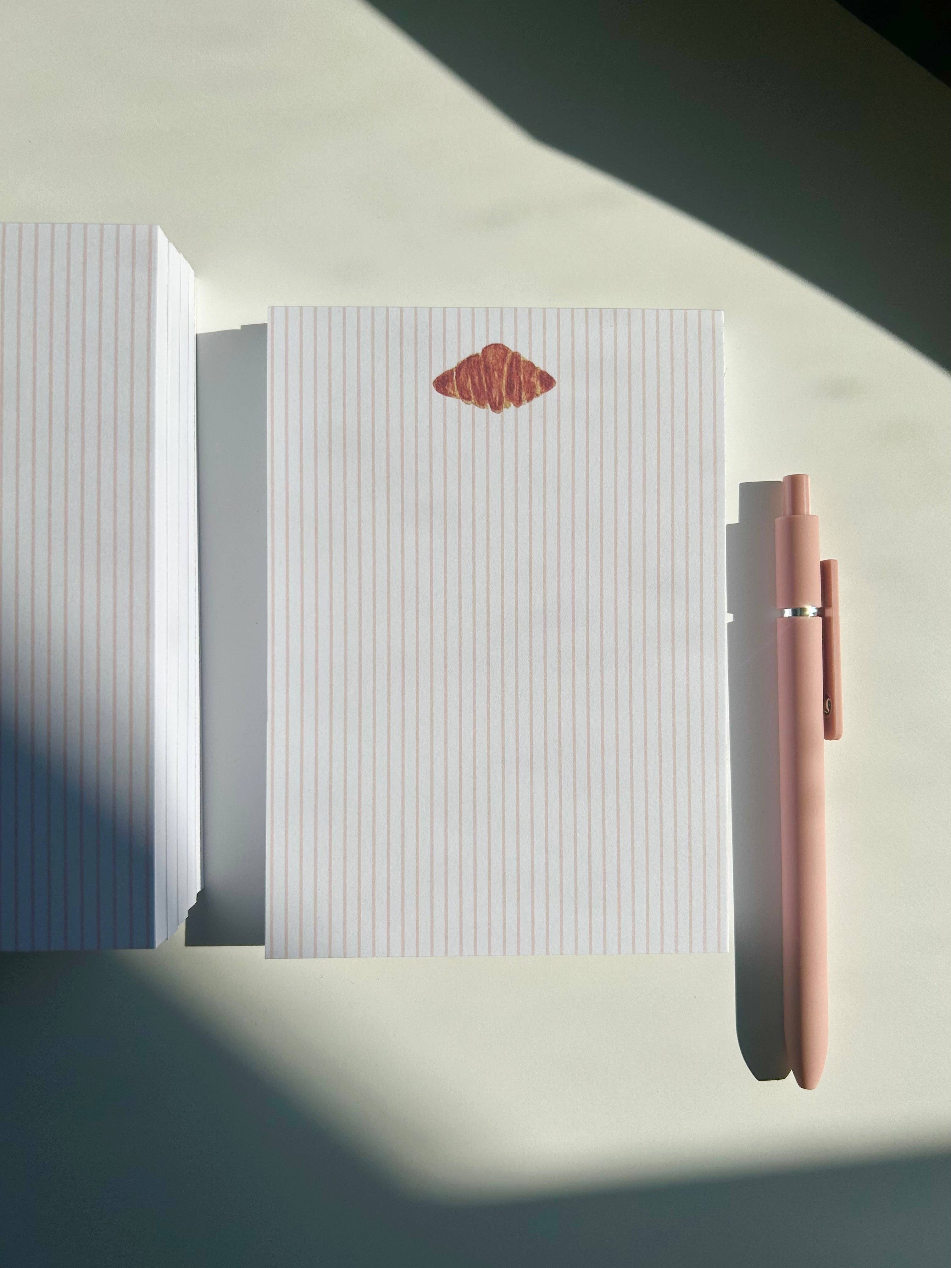 Χειροποίητο μπλοκ σημειώσεων SANS.design με σχέδιο κρουασάν σε τεχνική watercolor, 50 φύλλα, μέγεθος A6.