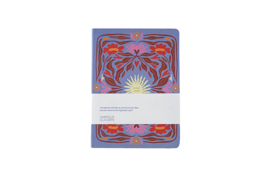 Εβδομαδιαίο ημερολόγιο A-Journal Fabrique 2026 με υφασμάτινη υφή και σχέδιο ήλιου σε λιλά/λεβάντα φόντο.