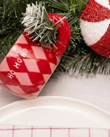 Χειροποίητη κεραμική κούπα Qué Rico Natalia με πολύχρωμο μοτίβο Harlequin σε κόκκινο και ροζ, και χαρακτηριστική στριφτή λαβή.