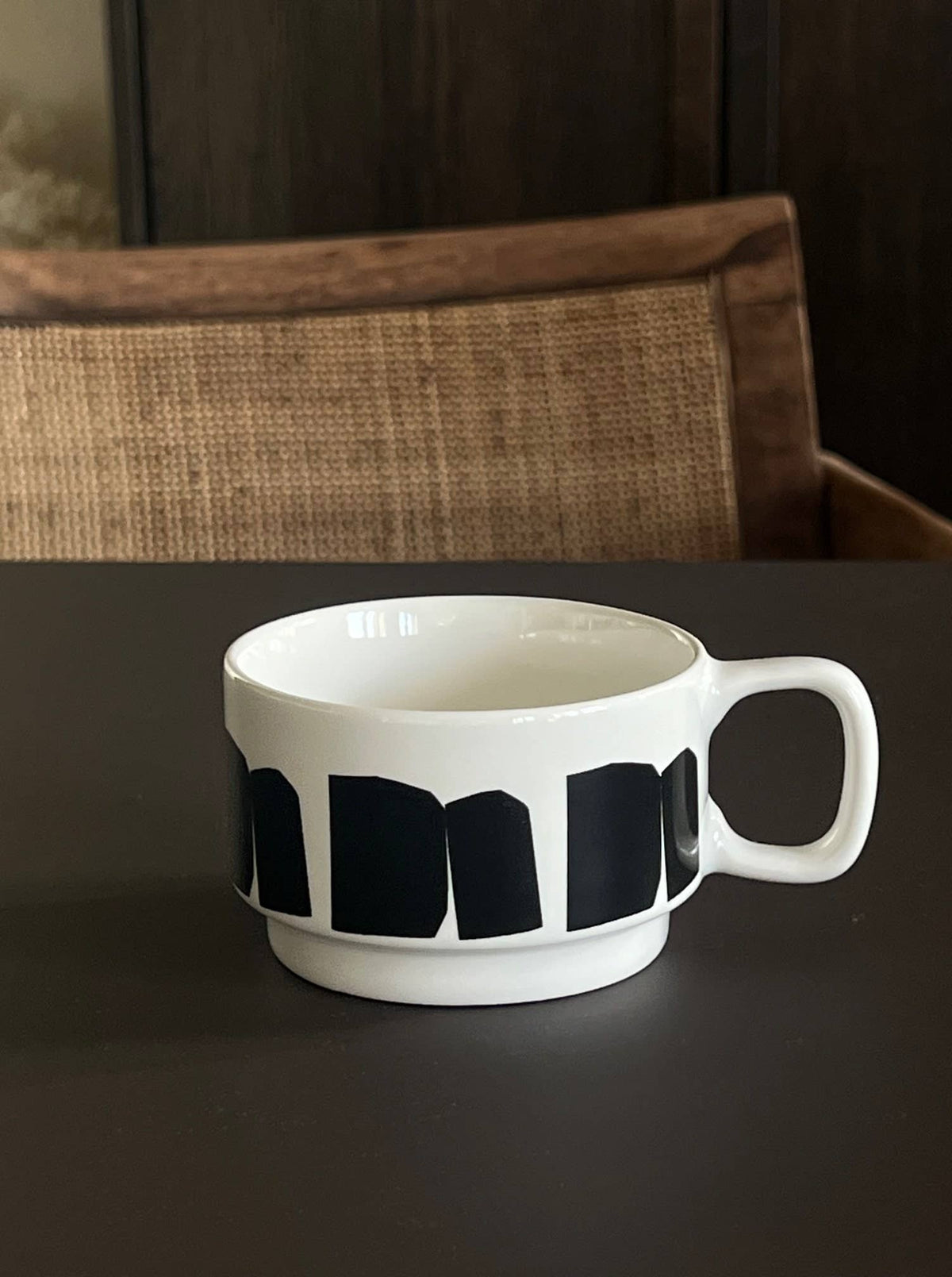 Χειροποίητη κεραμική κούπα σε off-white χρώμα με μαύρο αφηρημένο γραφικό σχέδιο και γυαλιστερό φινίρισμα.