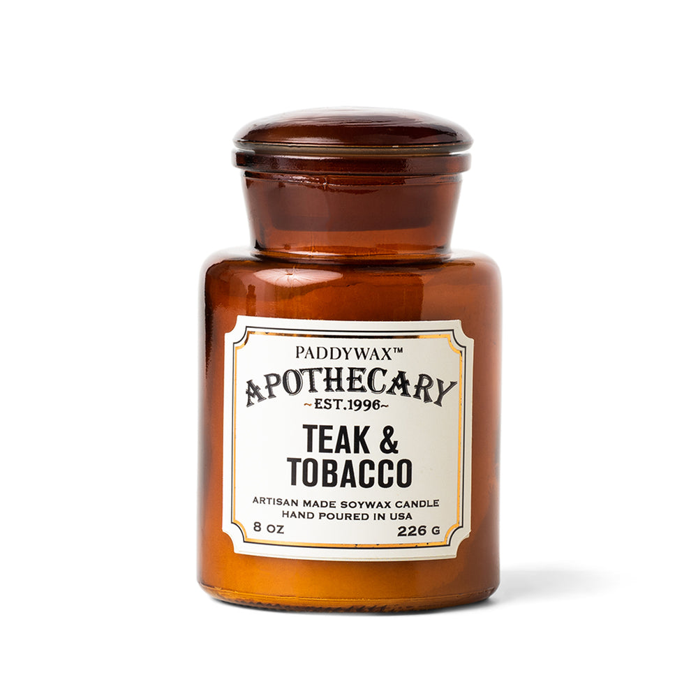 Αρωματικό κερί σόγιας Paddywax Apothecary Teak & Tobacco 226g σε κεχριμπαρένιο γυάλινο βάζο φαρμακείου.