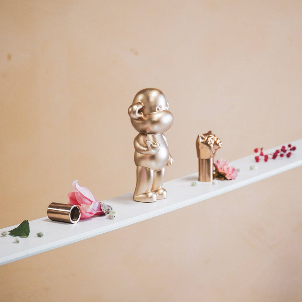 Διακοσμητική χρυσή μαϊμού House Vitamin σε μέγεθος Medium, που κάνει τη χειρονομία "Hang Loose".
