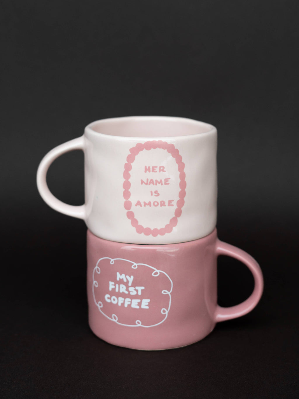 Χειροποίητη κεραμική κούπα σε off-white χρώμα με τη μαύρη επιγραφή "my first coffee" και γυαλιστερό φινίρισμα.